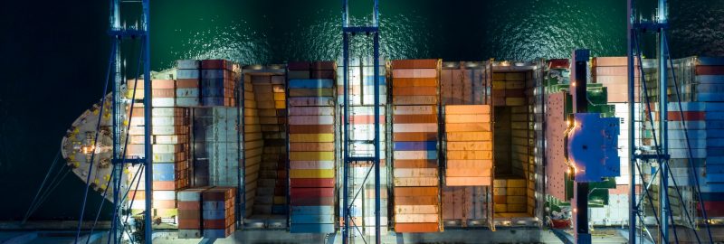 Aerial view At  container terminal,crane lifts container from ship to  truck to deliver  goods to customer,Industrial business import and export Logistics and Supply Chain.