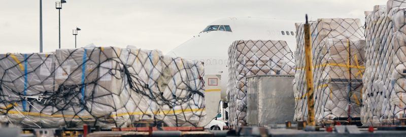 Preparation freight airplane before flight. Loading of cargo containers to plane at airport.